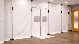 temporary containment barrier constructed with white polyethylene sheeting