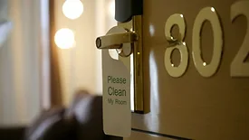 Room service. Woman making bed in hotel room. House Cleaner preparing everything for clients to move in