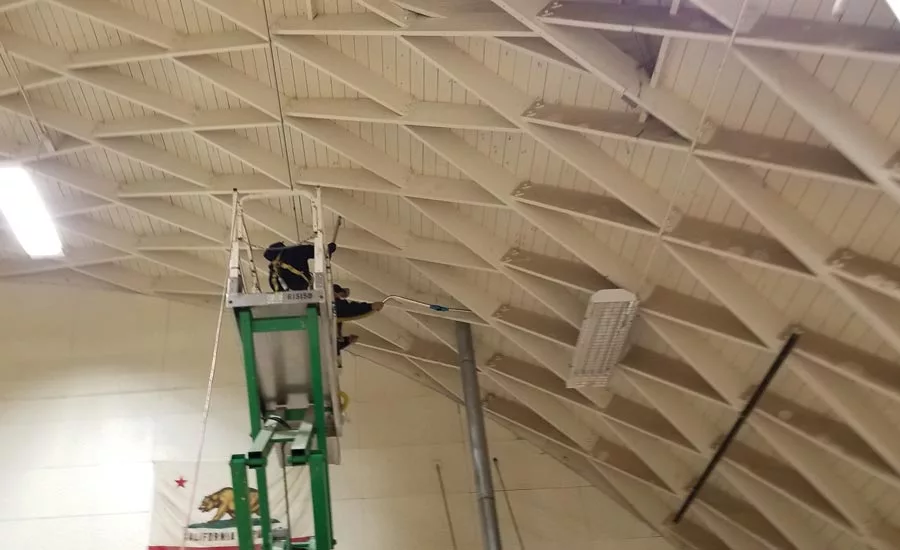 Cleaning the gym ceiling.