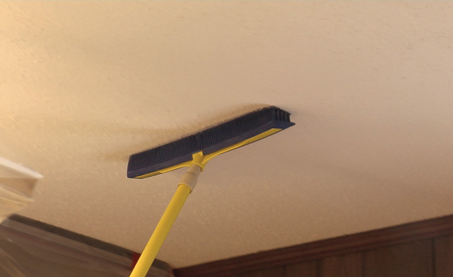 using a broom on the ceiling