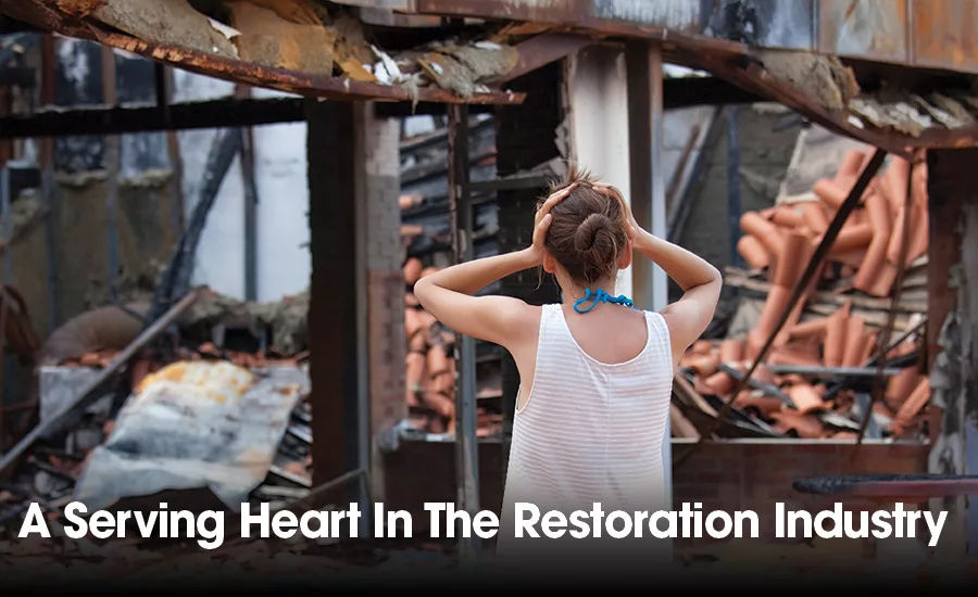 grief-stricken person in front of a destroyed home