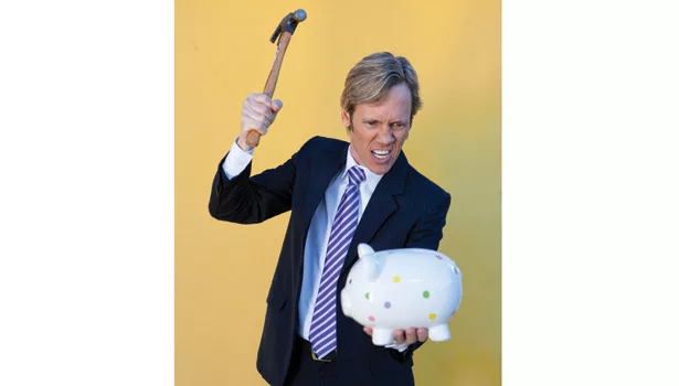 cross stock photo man breaking piggy bank