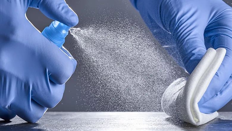 treating a table with a disinfectant spray