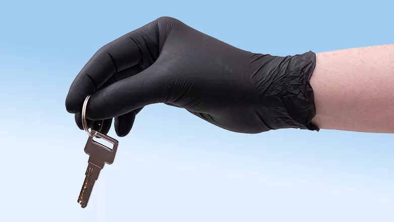 Hand in black safety glove with key