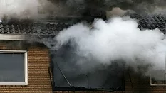 a house consumed in smoke and fire
