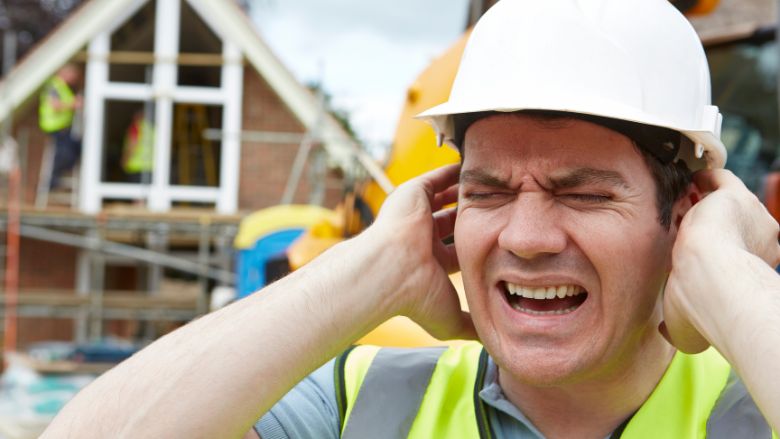 Construction worker suffering from noise on a building site