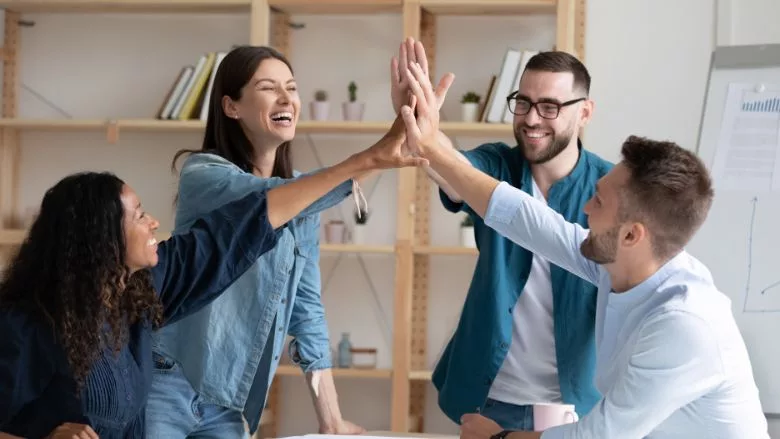 employees giving high five at corporate meeting