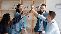 employees giving high five at corporate meeting