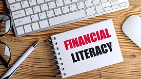 Financial Literacy text on spiral notepad on desk