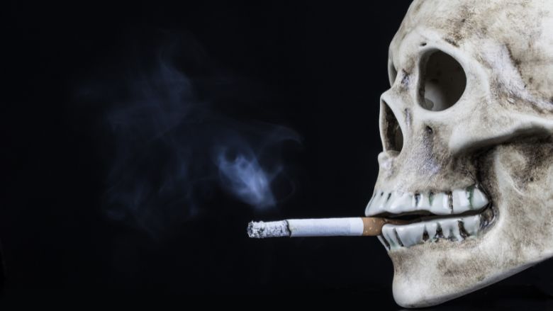 human skull with a cigarette in its mouth