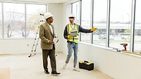 construction worker shows the city inspector around the retail space