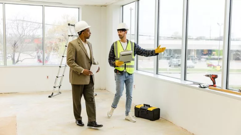 construction worker shows the city inspector around the retail space