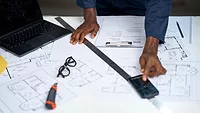 construction worker using smartphone over architectural plans construction worker using smartphone over architectural plans