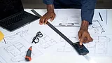 construction worker using smartphone over architectural plans
