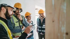A man explaining the project to three workers/students