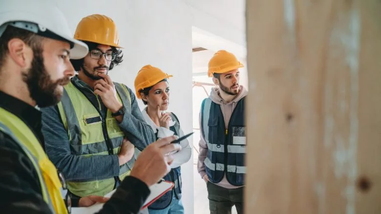A man explaining the project to three workers/students