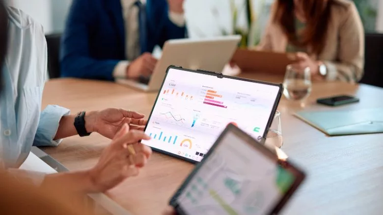 Business team analyzing financial data on digital tablets during a meeting