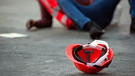 injured worker on the ground with hard hat in the foreground
