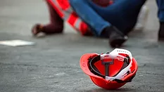 injured worker on the ground with hard hat in the foreground