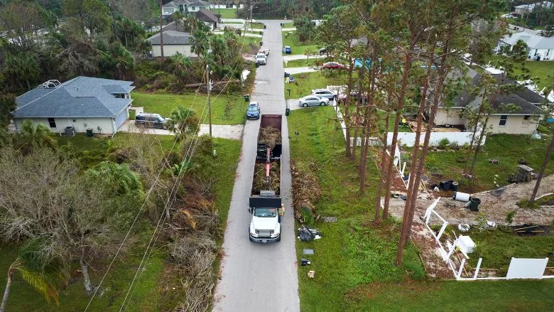 dump truck picking up vegetation from Florida streets in the aftermath of Hurricane Ian