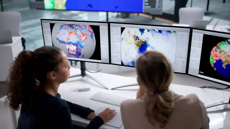 Analyzing Weather Patterns on Computer with Forecast Map for Tracking