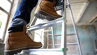 Professional constructor on ladder in old building Professional constructor on ladder in old building