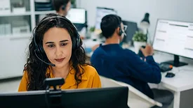 support agent speaking clearly with a headset in a modern office