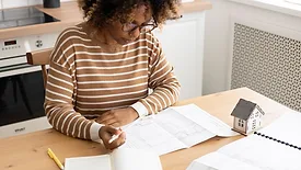 Female architect is working, taking notes in notebook