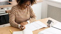 Female architect is working, taking notes in notebook