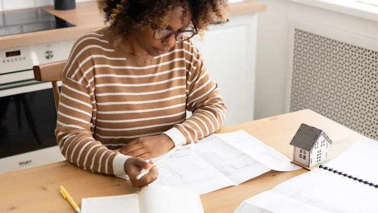 Female architect is working, taking notes in notebook