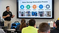 Restoration and cleaning professionals participate in a classroom training session focused on water damage restoration processes, equipment, and industry best practices