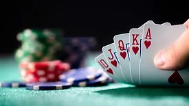 Playing poker in a casino holding winning royal flush