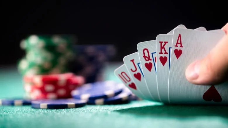 Playing poker in a casino holding winning royal flush