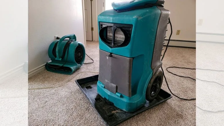 Air mover and a dehumidifier drying out the flooring and walls in a home
